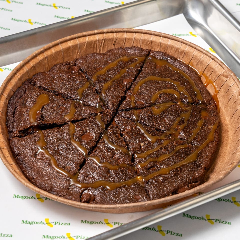 A Magoo's California Pizza brownie dessert, cut into slices and drizzled with caramel sauce.