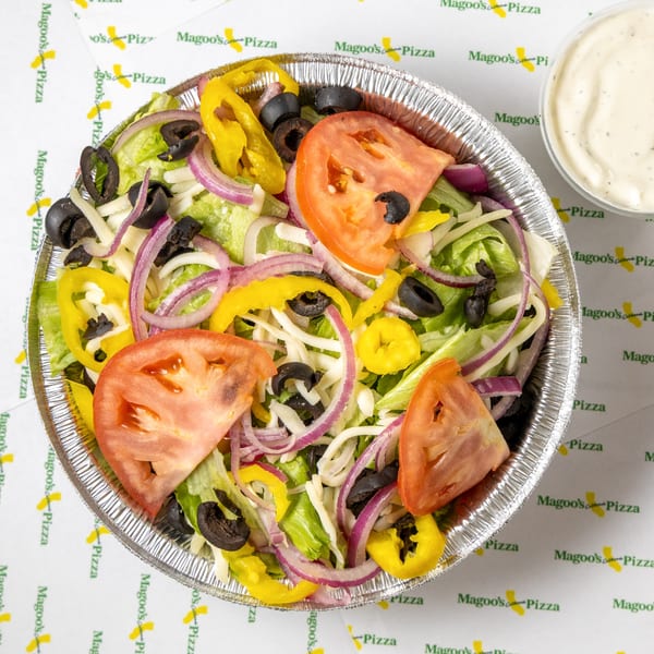 A Magoo's California Pizza salad with lettuce, tomatoes, olives, onions, and yellow peppers.