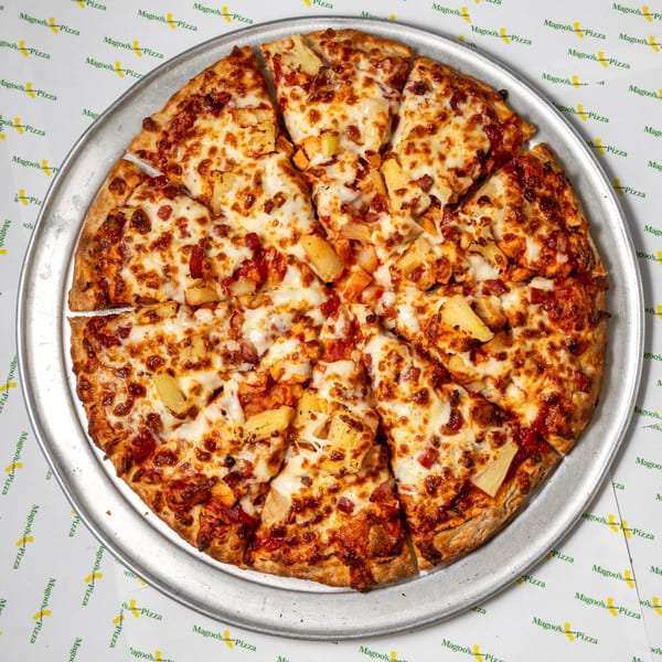 Magoo's California Pizza with pineapple, bacon, and chicken on a metal tray.