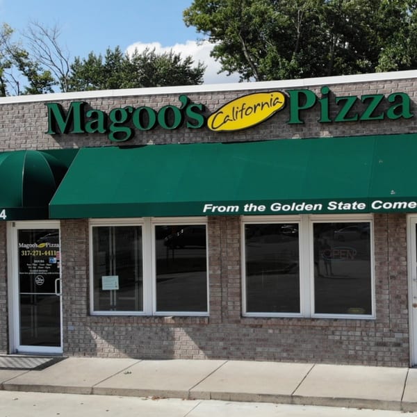 Exterior of Magoo's California Pizza, a brick building with green awnings and signage.