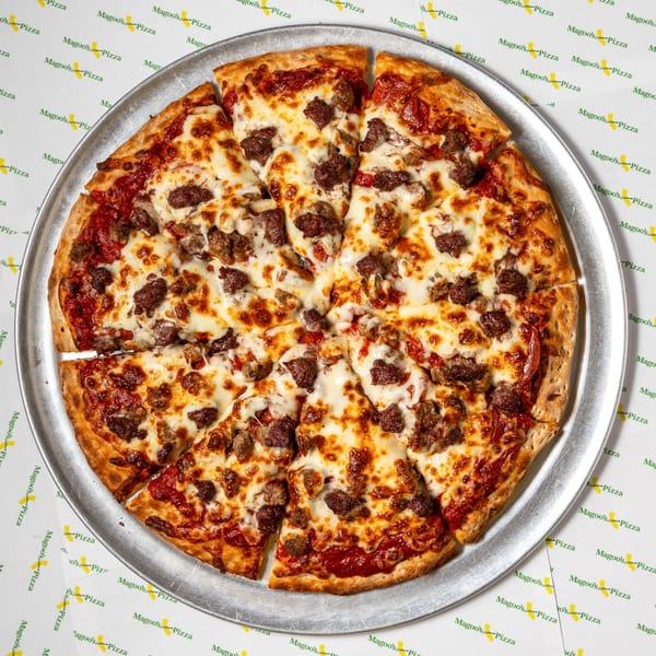 A Magoo's California Pizza with sausage and cheese, sliced on a metal tray.